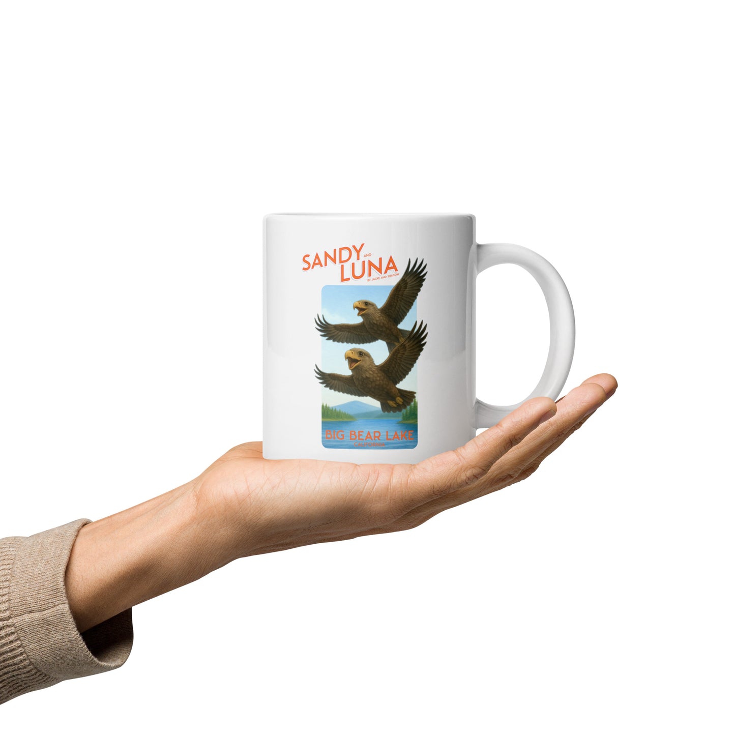 White mug with bird design held in a hand against a white background