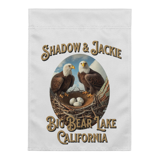 A white rectangular fabric item, likely a towel or flag, featuring a printed graphic of two bald eagles at a nest with the text 'SHADOW & JACKIE' above and 'BIG BEAR LAKE CALIFORNIA' below.