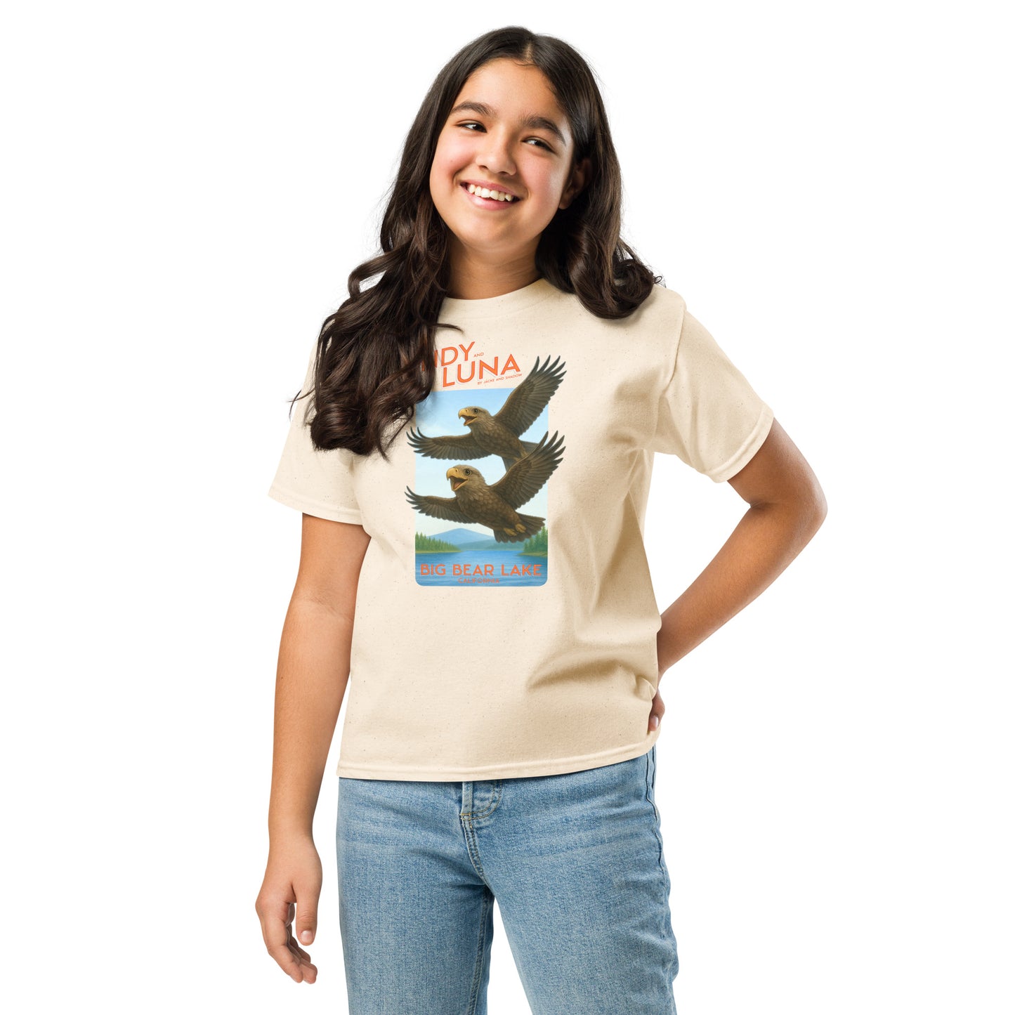 Young girl wearing a beige t-shirt with a graphic design on a white background