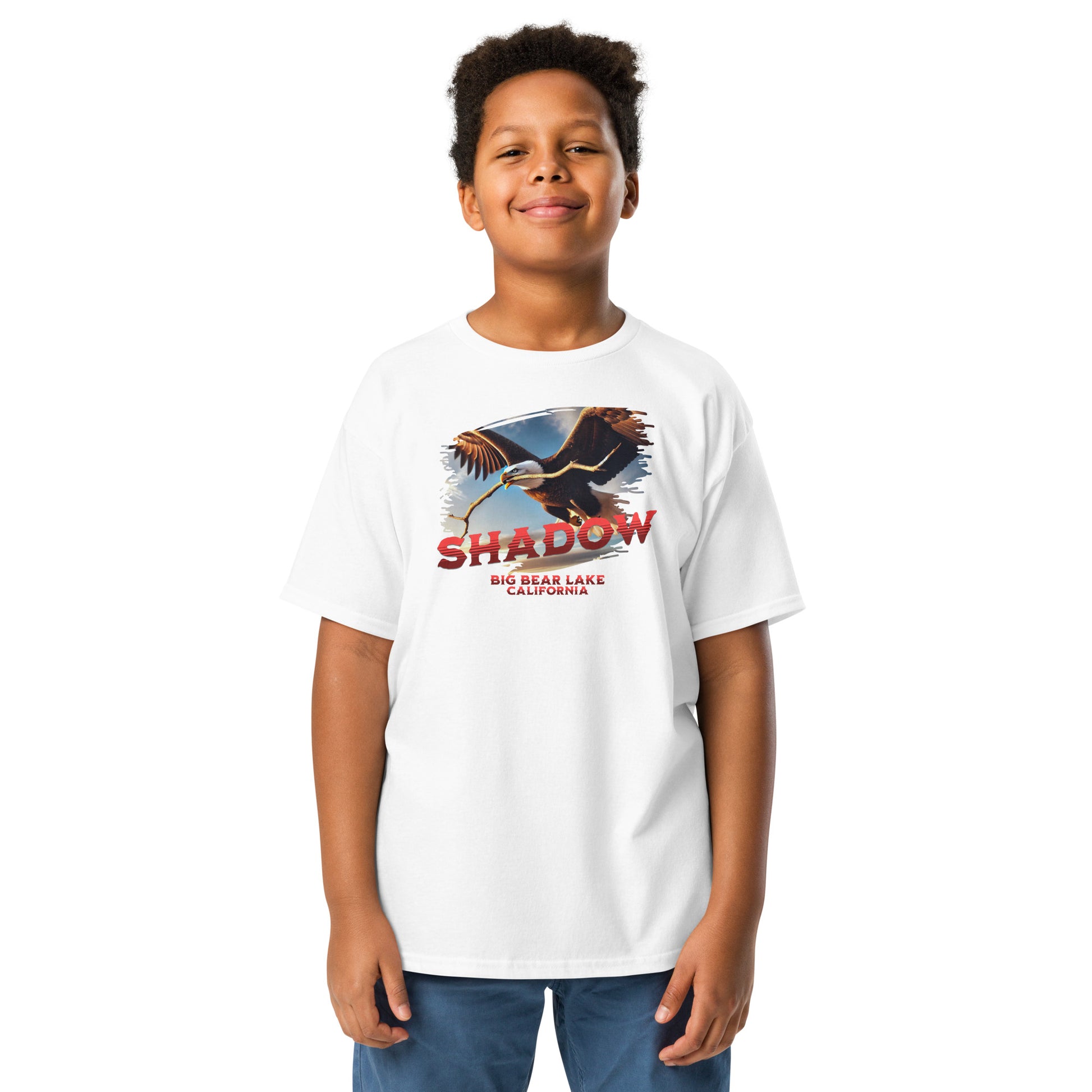 Youth t-shirt featuring Shadow the bald eagle flying with a stick in his beak over Big Bear Valley, inspired by his nest-building for Jackie.